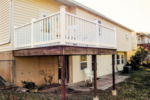 rear view of house with central air condition unit, a patio area, and a balcony