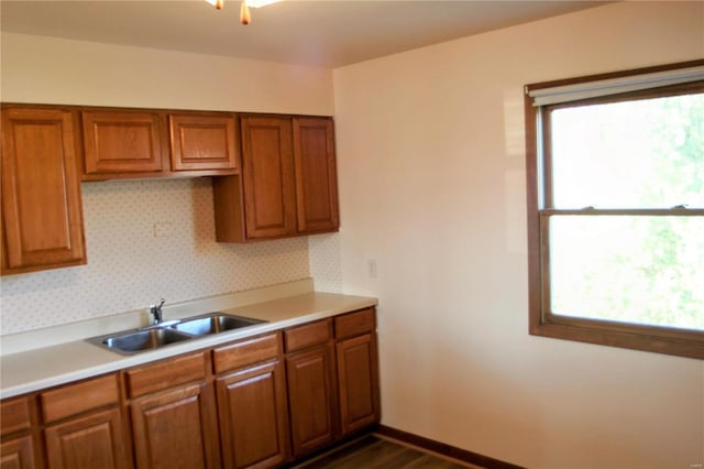 kitchen with backsplash, dark hardwood / wood-style flooring, a wealth of natural light, and sink