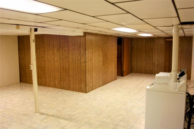 basement with wooden walls and a drop ceiling