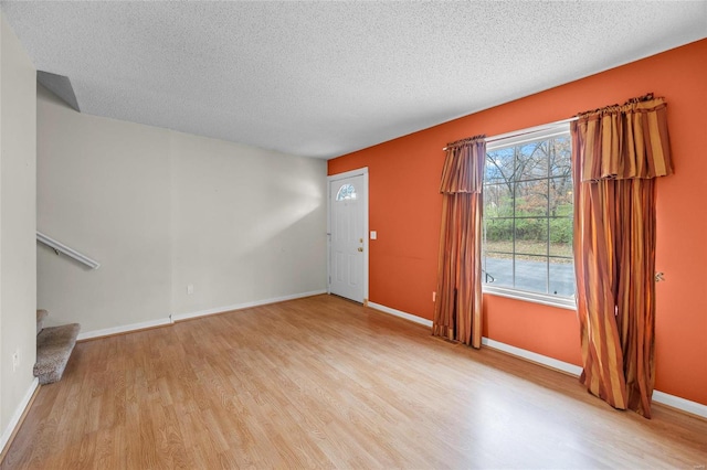 interior space with a textured ceiling and light hardwood / wood-style floors