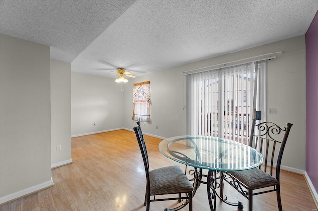 dining room with light wood-type flooring, a textured ceiling, and ceiling fan