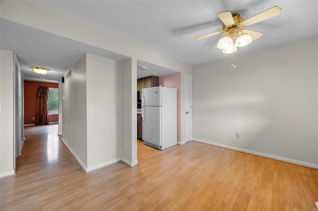 unfurnished room featuring ceiling fan, light hardwood / wood-style flooring, and a textured ceiling