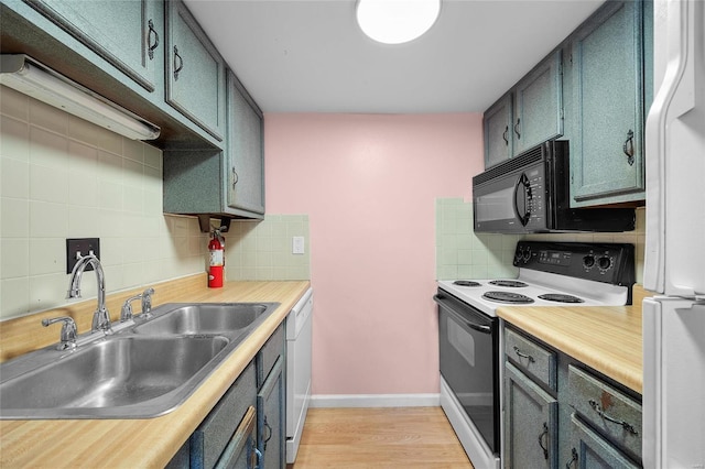 kitchen featuring decorative backsplash, white appliances, light hardwood / wood-style flooring, and sink