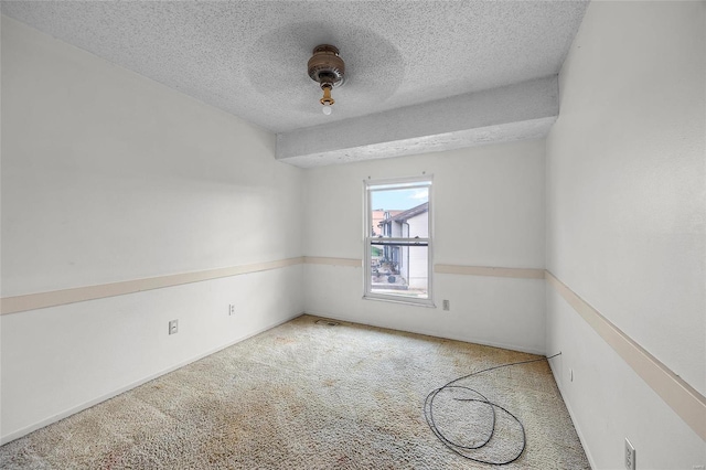 carpeted spare room featuring a textured ceiling and ceiling fan