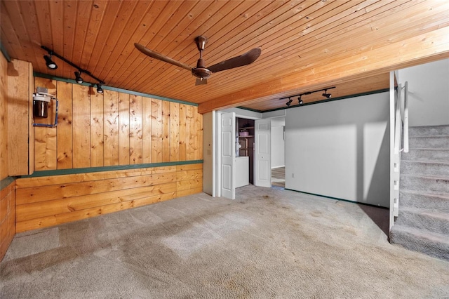 interior space with carpet floors, ceiling fan, wooden walls, and wood ceiling