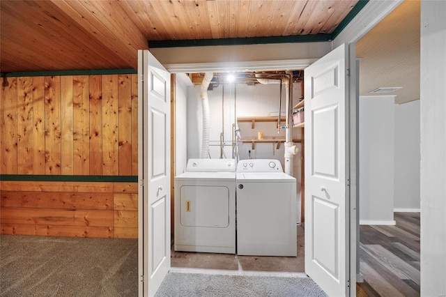 washroom with wooden ceiling, separate washer and dryer, hardwood / wood-style flooring, and wooden walls