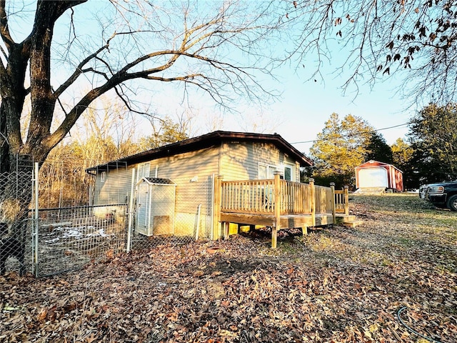 view of side of property with a deck, a garage, and an outdoor structure