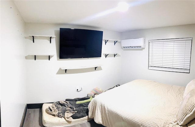 bedroom featuring a wall mounted air conditioner and hardwood / wood-style flooring