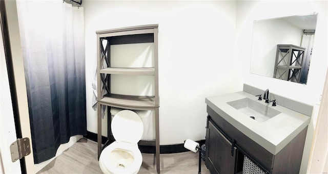 bathroom featuring vanity, toilet, and wood-type flooring