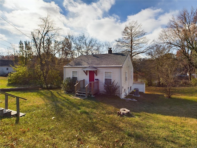 view of front of home featuring central AC unit and a front yard