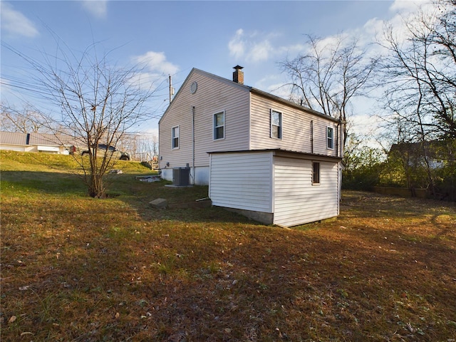 view of side of property with a yard and central AC unit