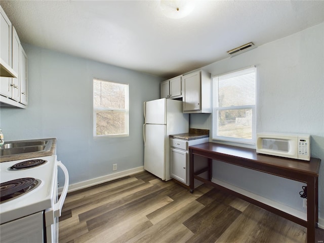 kitchen with white cabinets, white appliances, and dark wood-type flooring