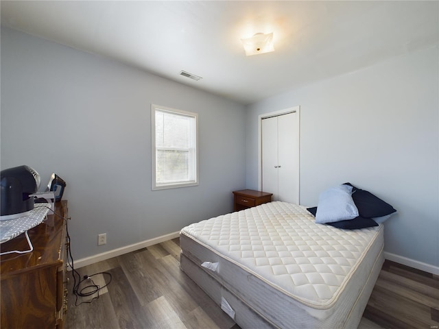 bedroom with a closet and dark hardwood / wood-style floors