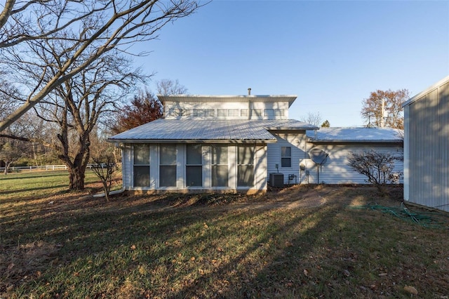 rear view of house with a lawn, central AC, and a sunroom