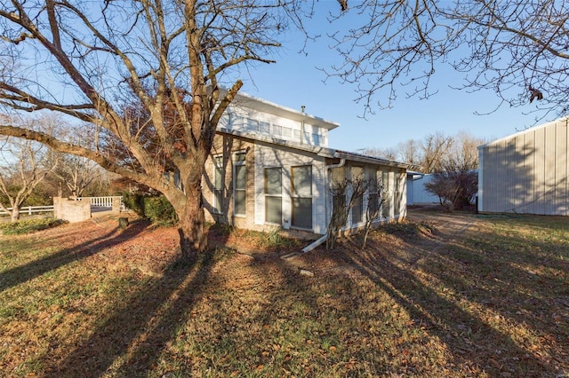 rear view of property featuring a lawn