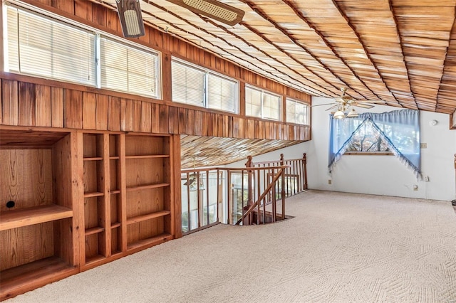 interior space with carpet, ceiling fan, wood walls, and wood ceiling