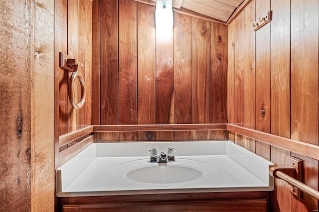 bathroom featuring wooden walls and vanity