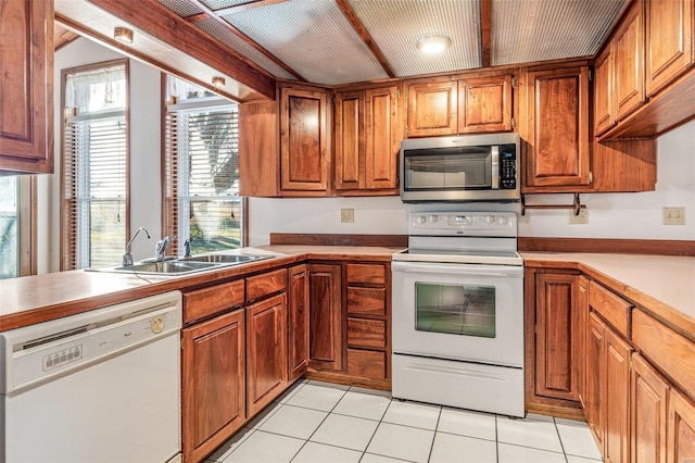 kitchen featuring sink, white appliances, kitchen peninsula, and light tile patterned flooring