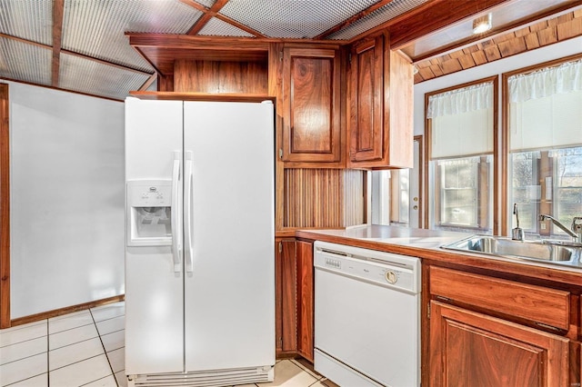 kitchen featuring light tile patterned flooring, white appliances, and sink