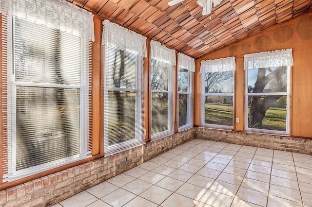 unfurnished sunroom featuring ceiling fan, lofted ceiling, and a wealth of natural light