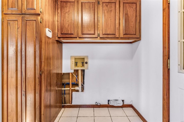 clothes washing area featuring cabinets, electric dryer hookup, hookup for a gas dryer, hookup for a washing machine, and light tile patterned flooring