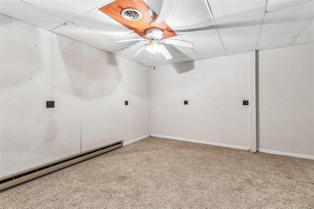 carpeted empty room with a paneled ceiling, ceiling fan, and a baseboard radiator