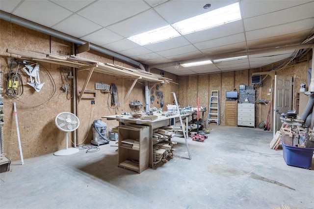 basement featuring a workshop area and a paneled ceiling