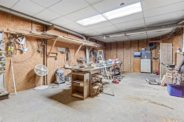 basement featuring a workshop area and a drop ceiling