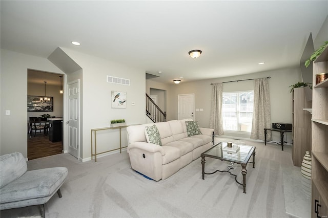 carpeted living room featuring a chandelier