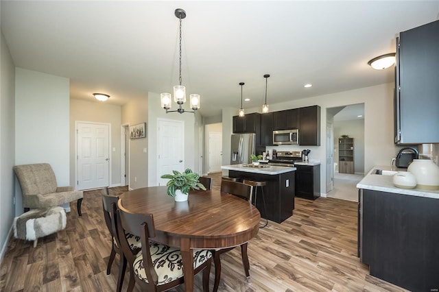 dining area featuring hardwood / wood-style flooring, a notable chandelier, and sink