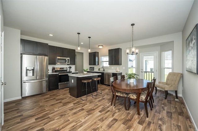 dining room with sink, dark wood-type flooring, and a notable chandelier