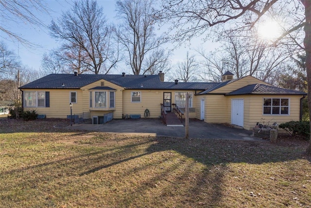 rear view of property featuring a patio area and a yard