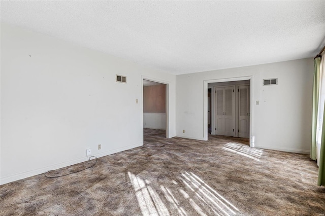 spare room with carpet flooring and a textured ceiling