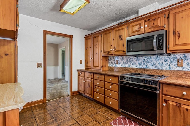 kitchen featuring backsplash, black stove, and a textured ceiling