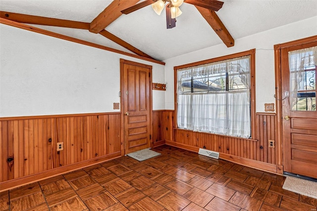 entrance foyer with plenty of natural light, wood walls, and a textured ceiling