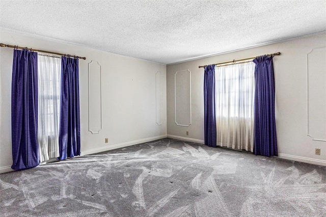 carpeted empty room featuring a textured ceiling