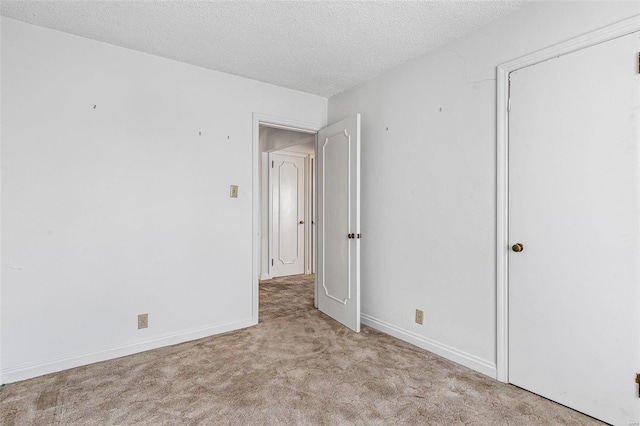 carpeted empty room with a textured ceiling