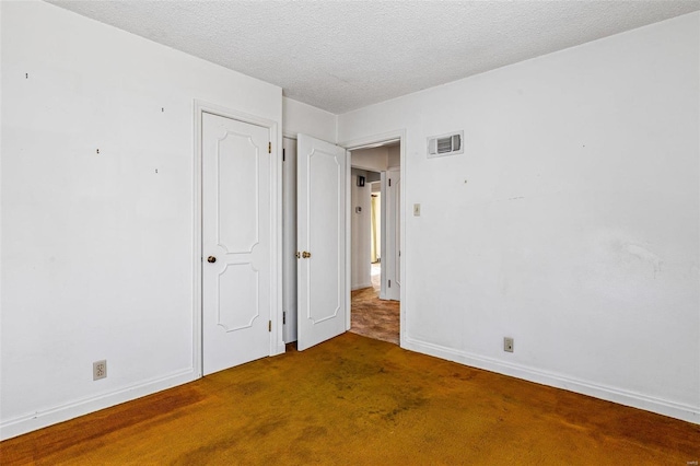 unfurnished bedroom featuring carpet flooring and a textured ceiling