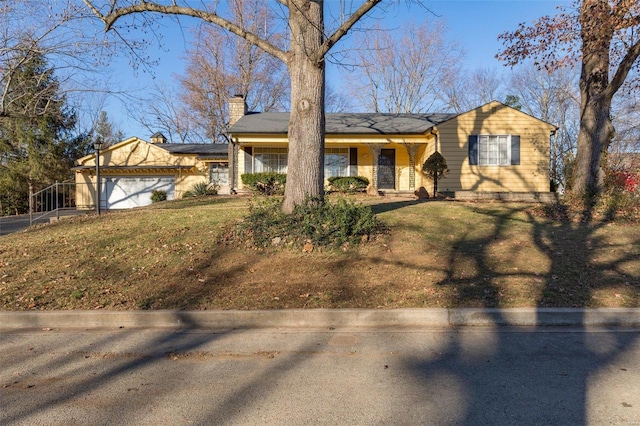 view of front of property featuring a front yard and a garage