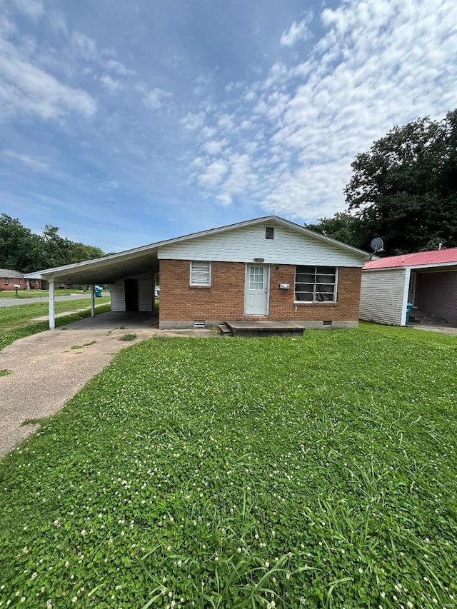 view of front of home with a carport and a front lawn