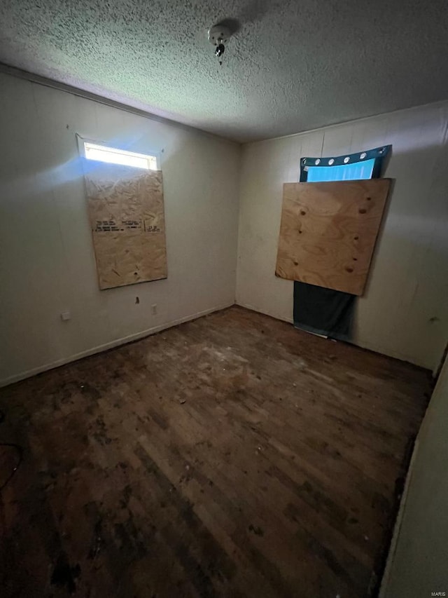 unfurnished room featuring dark hardwood / wood-style floors and a textured ceiling