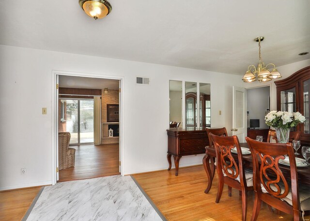 dining area with hardwood / wood-style floors and a notable chandelier