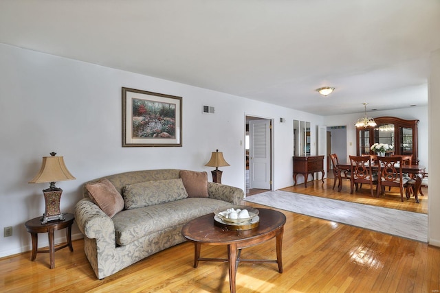 living room featuring light hardwood / wood-style floors and a chandelier