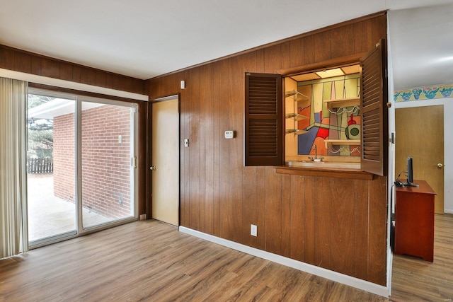 spare room with wooden walls and light hardwood / wood-style floors