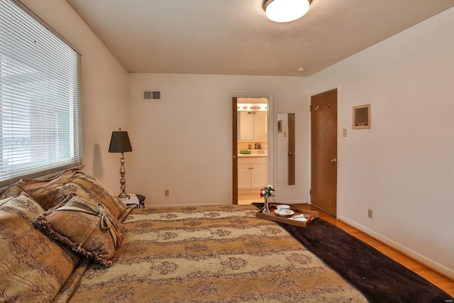 bedroom with wood-type flooring and ensuite bathroom