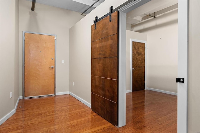 hall featuring wood-type flooring and a barn door