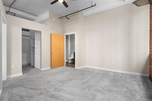 unfurnished bedroom with ceiling fan, ensuite bath, carpet floors, and a closet