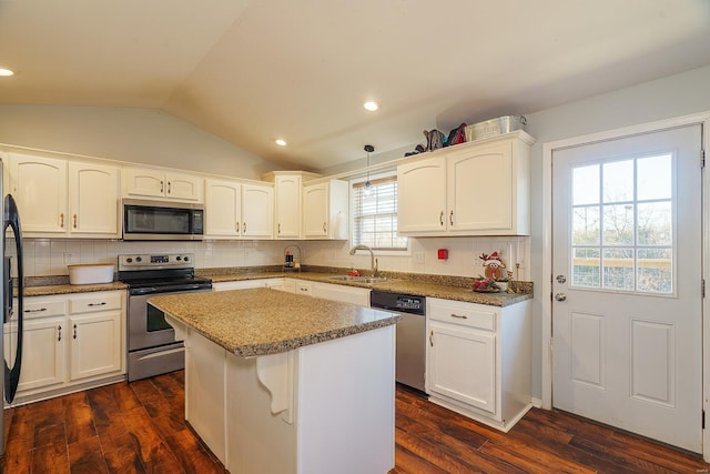 kitchen featuring pendant lighting, dark hardwood / wood-style flooring, stainless steel appliances, and vaulted ceiling