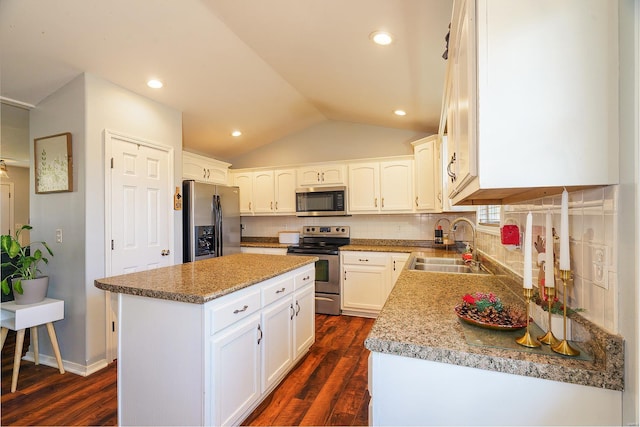 kitchen featuring dark hardwood / wood-style flooring, a kitchen island, vaulted ceiling, and appliances with stainless steel finishes