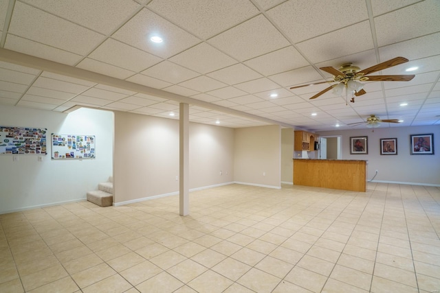 basement with ceiling fan and a drop ceiling